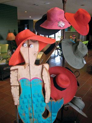 A unique wooden mermaid

adorned with accessories by San Diego Hat Co. greets customers as

they approach the checkout counter