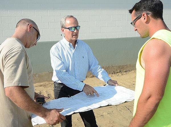 Building plans: Mike Giovanone (center) discusses the distribution center with two contractors.