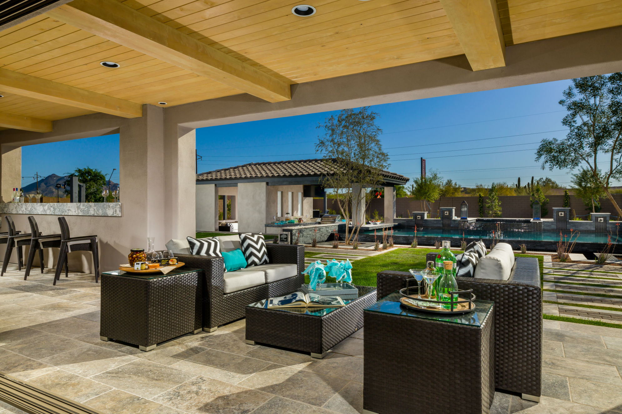 The outdoor area of this Toll Borthers home consists of four lounging and dining spaces with a total of four televisions. Two outdoor kitchens come complete with all the essentials, including an al fresco space to the right of the pool area. Revelers also can enjoy two outdoor living rooms with a fire feature, raised sun deck, and a bocce ball court. 