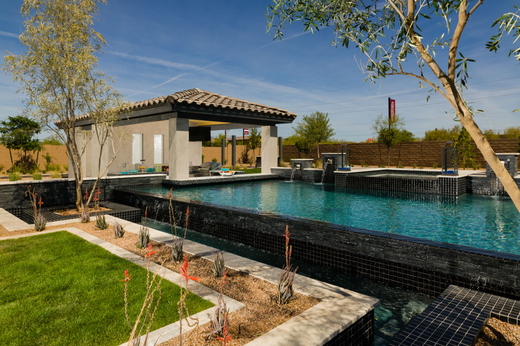 This pool in Phoenix features a sleek reverse negative-edge with swim-up bar, sun shelf, hot tub and waterfeature. For Sonoran Landesign Custom Pools' general manager Travis McFarlin, the standout element of the space — one his colleagues thought impossible until implemented — are the two large olive trees set in planters shotcreted into the front of the negative-edge basin, which give the effect of the trees growing out of the pool. 