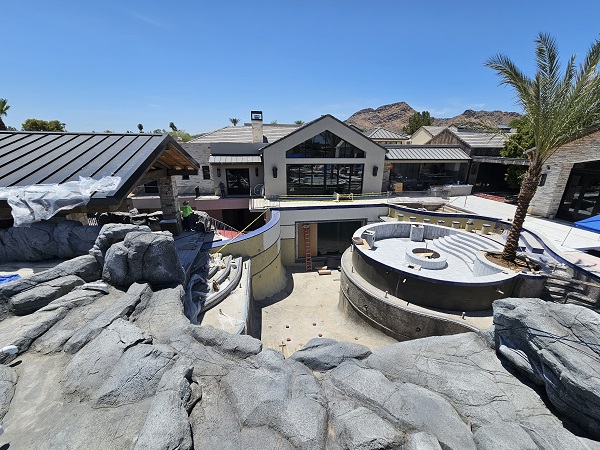 The main pool reaches 17-foot depths. The area with the palm tree, to the right, is the floating firepit. Behind it, with the red ladder in front, is a window that will be submerged when the pool is filled.