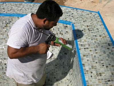 Crews place the joints in waterline tile and on a corner, using a sealant that closely matches the grout in color.