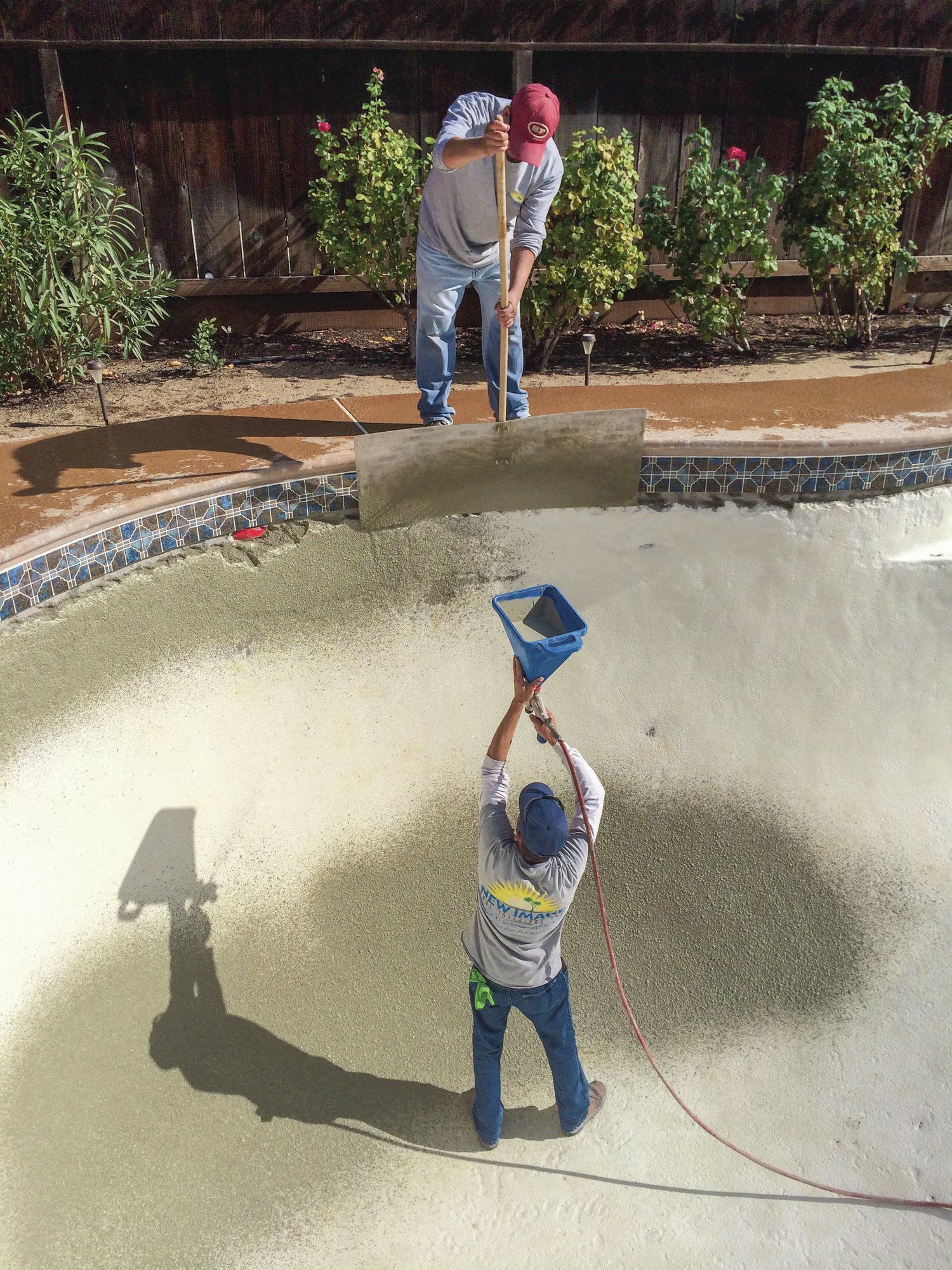 Right technique: Spraying the bond coat material is pricier because of the equipment investment, but it also helps assure the right, stippled texture for proper adhesion of the finish coat. Above, while applying the bond coat material, crews hold the hopper gun perpendicular to the surface to assure the most material will stick. Otherwise, it will hit the substrate at an angle and some will bounce off. The compressor should be adjusted to release the right amount of air.