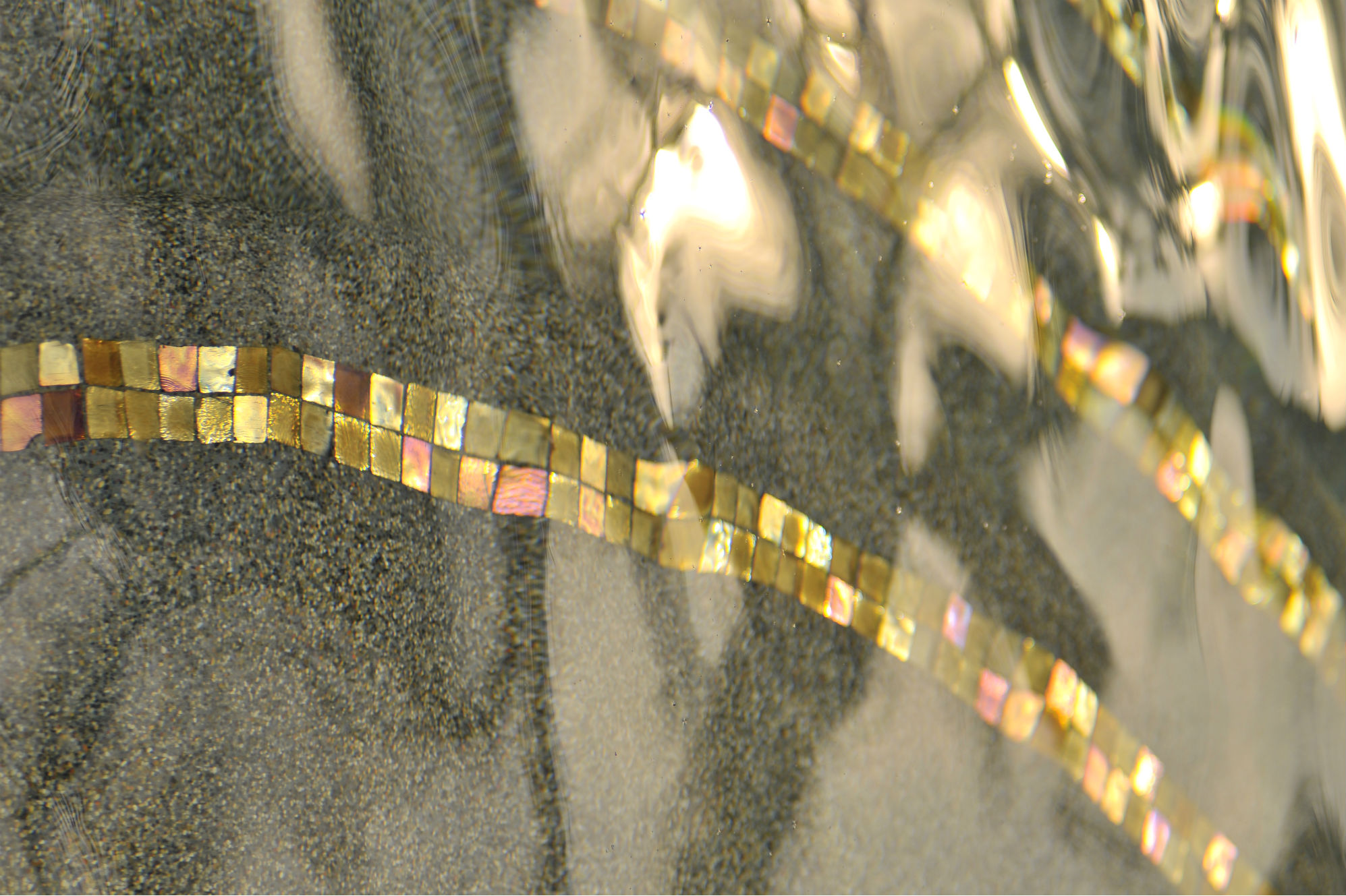 A close-up of the iridescent tile captures the beauty and movement of the subtle design touch that adds an additional layer of sophistication to this project designed by Conscious Environments. 