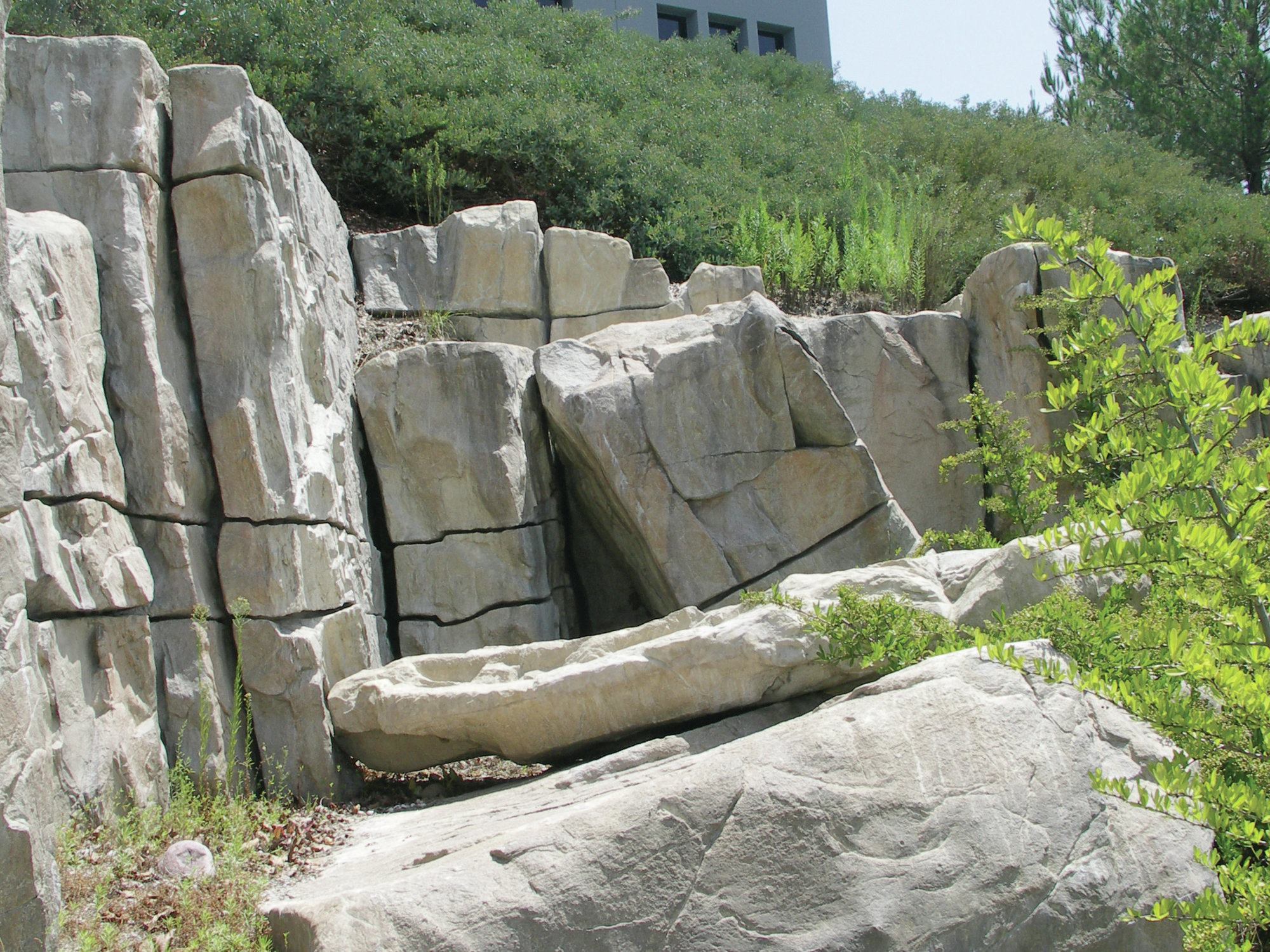 Best practices: Rock formations evolve over time and the most realistic non-natural installations reflect this. Here, a large piece appears to have split from the main formation and fallen to the ground.