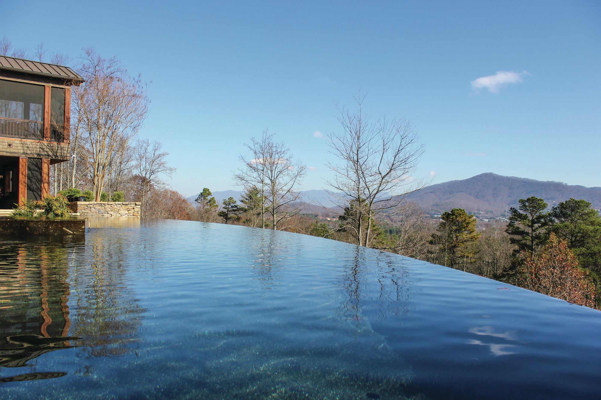 The design team chose to cap the vanishing edge weir with a fossilized marble from Morocco. The warm tones and embedded fossils echo the modern and rustic feel of the house; however, the material is not the most durable for enduring freeze/thaw conditions. For this reason, the team obtained extra stone with the intent of replacing pieces down the line. The material also veneers the raised perimeter sun shelf (not shown).