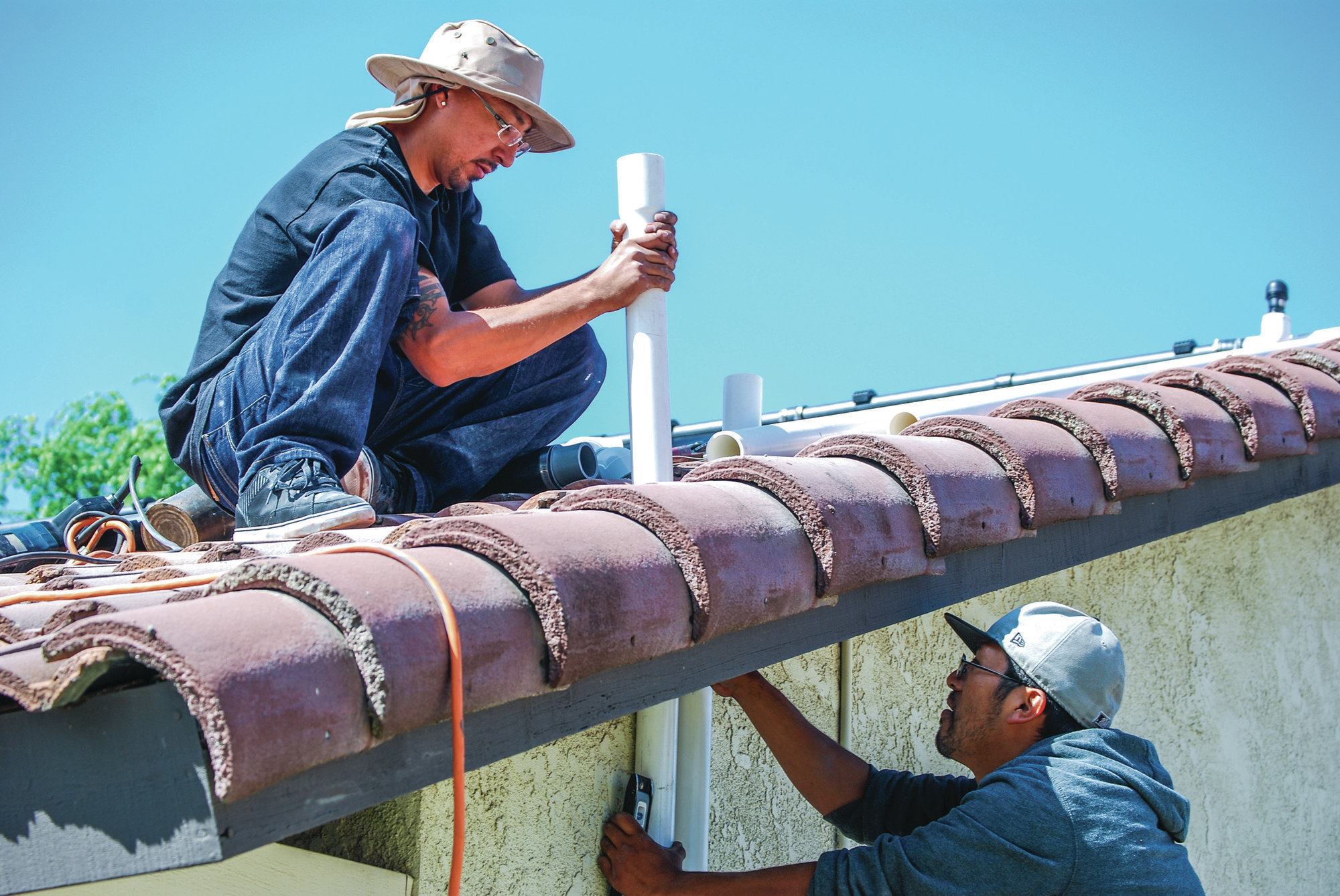 9) The lines are attached to the side of the house, while holes are cut in the roof to accept the pipes.