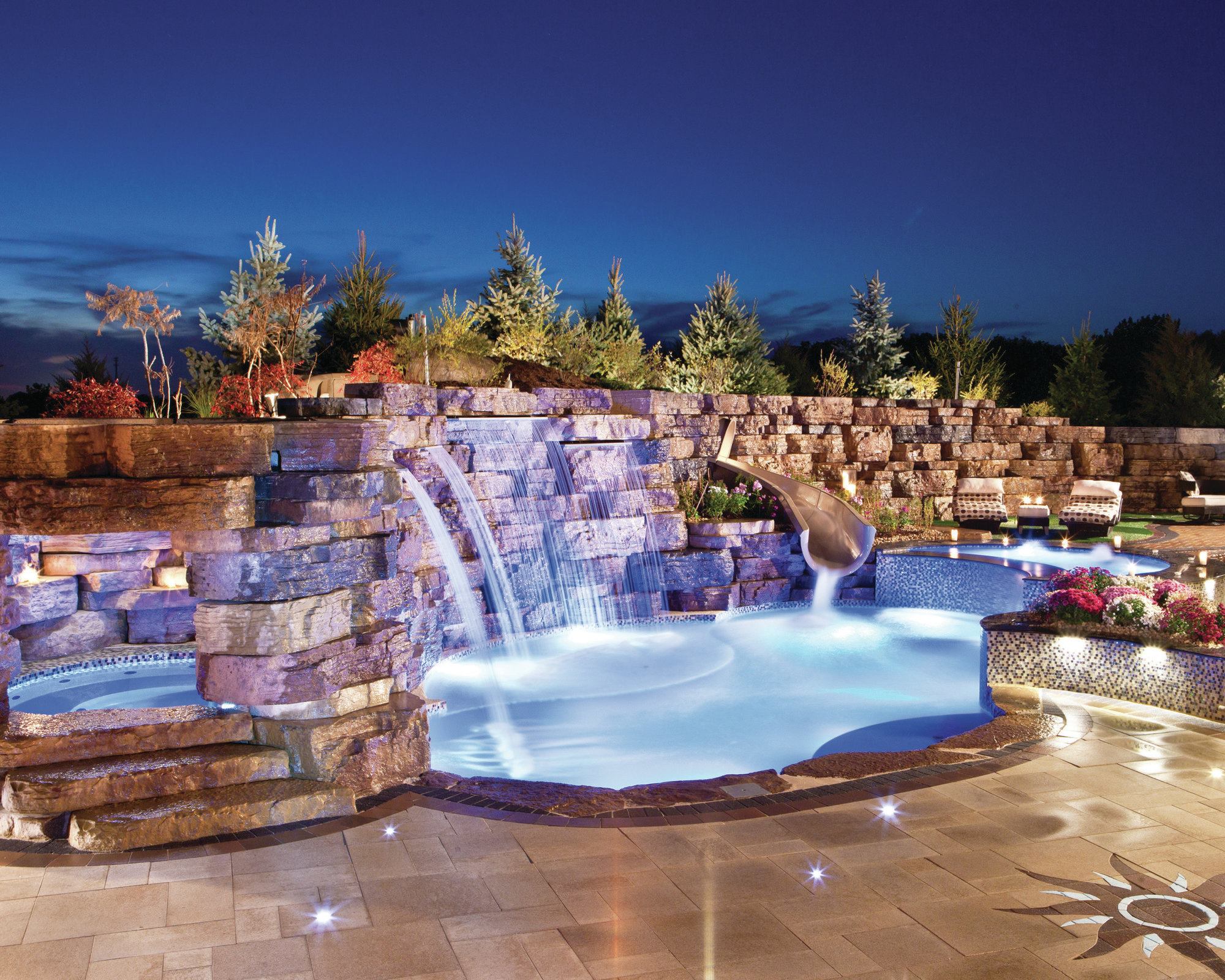 FLOWING DESIGN: To meet the homeowner’s demands, Emmerson trimmed down the sides of a compact pool and merged it with two tanning ledges. A shallower ledge on one side provides a wading area for the family’s three children. A second, crescent-shaped ledge was attached on the other side of the pool and cut along its front face to create a spillover waterfall into the pool.