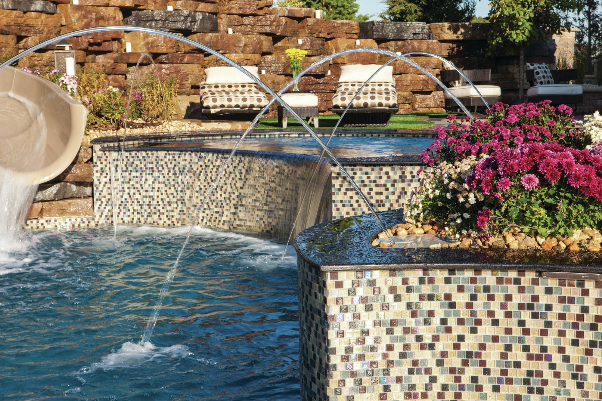 CROSSING ARCS: For many fiberglass pools, as much thought is put into the design of the spa and surrounding area as into planning the pool itself. This project, by Todd Emmerson of Signature Pools in Geneva, Ill., includes multiple laminar waterfeatures and elaborate stone work.