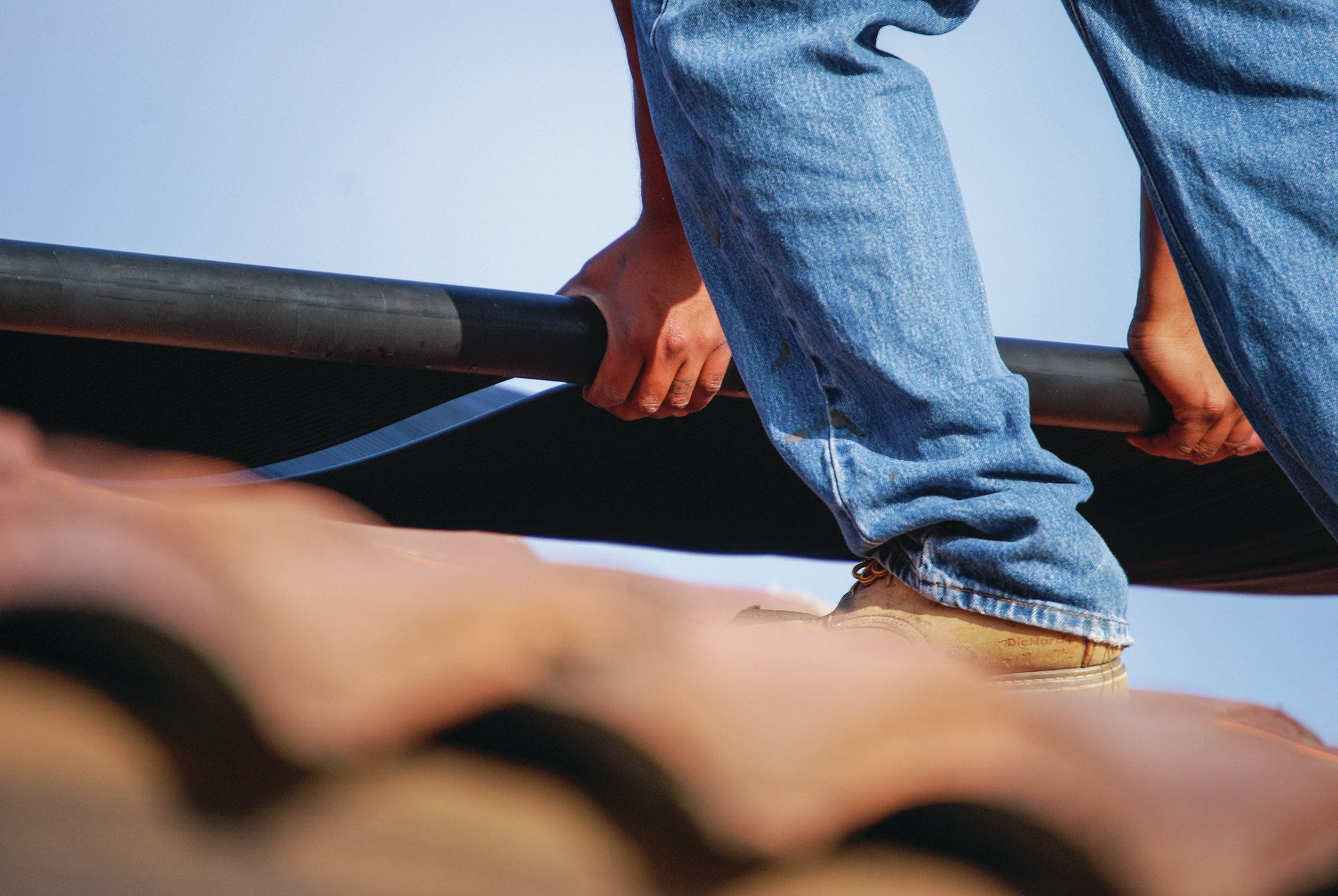 4) Brackets are used to hold the collectors to the roof at the top and bottom. In this case, lag bolts were placed through the brackets and into roof tiles. Other types of roofs may dictate a different approach.