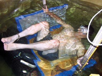 Writers of the drain-cover

standard have recently begun to perform more in-lab testing to

study the dynamics of body entrapment. Here, committee member Steve

Barnes “traps off” on a drain cover at NSF

International labs to compare the behavior of humans and blocking

elements under the same conditions.
