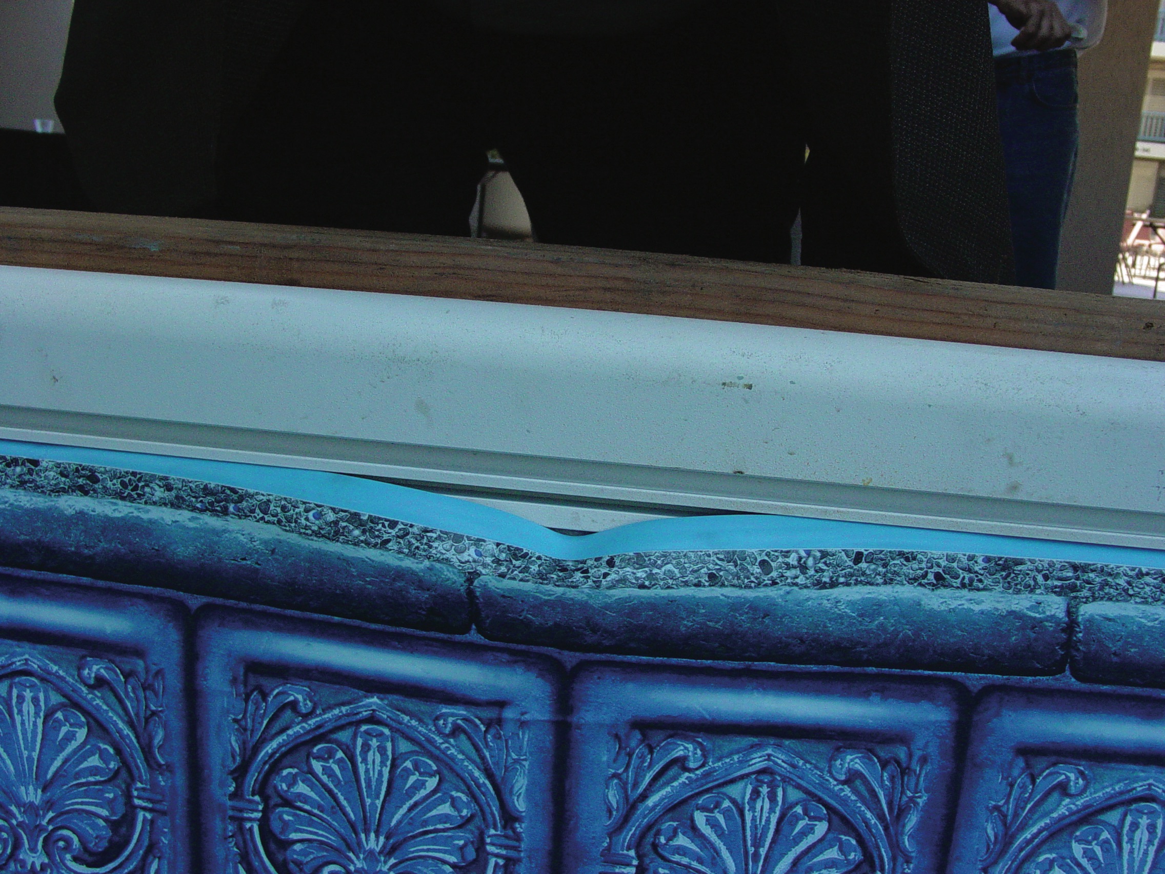 1. The weight of the water has caused a small part of the liner to sag. When the liner bead pops loose from the track, it resembles a grin. 