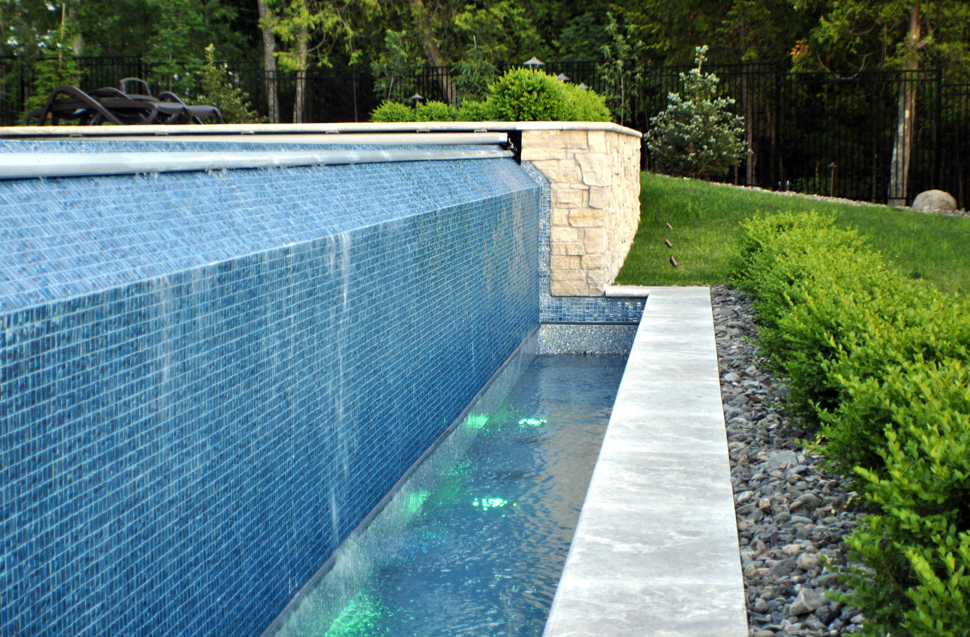 The vanishing edge is made from tile and the vinyl liner restarts in the basin. 